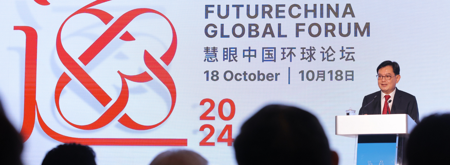 Man at podium for "Future China Global Forum," with logo and event details on backdrop.
